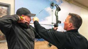 Cropped SGS98 Al Kraus Black Hills Archery assists a customer with setting the peep sight correctly copyright